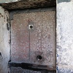 Close up of a cell door, showing the peep holes