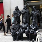 Men dressed in black posing as statues